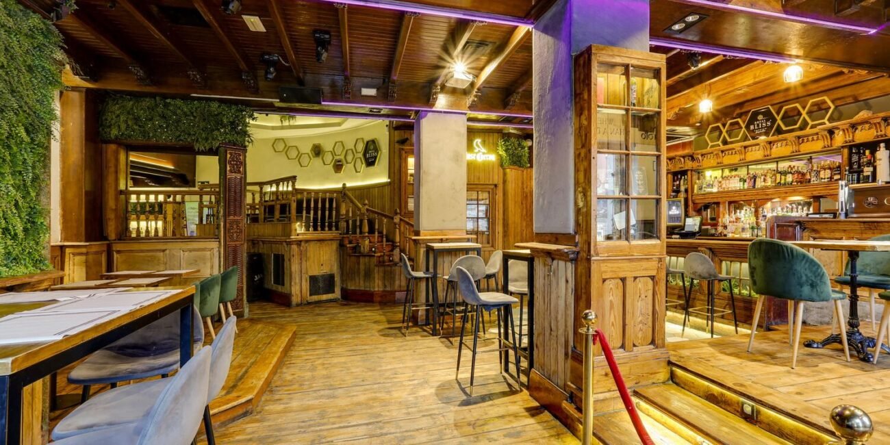 Amplio salón interior con mesas listas para recibir clientes en nuestro bar para celebrar cumpleaños en Madrid
