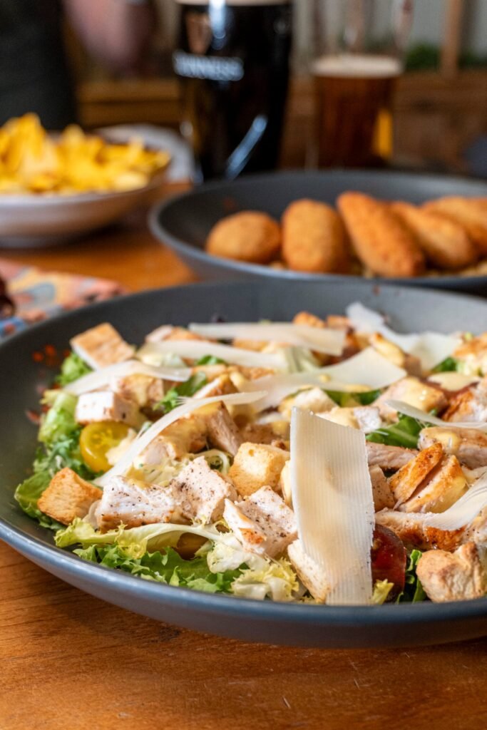 Ensalada césar fresca con pollo y picatostes en El Canalla sports bar en Madrid