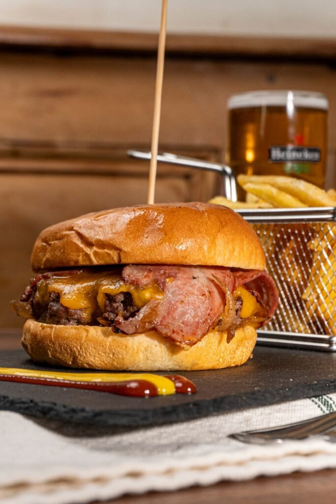 Jugosa hamburguesa completa acompañada de patatas fritas en El Canalla, irish pub en Madrid